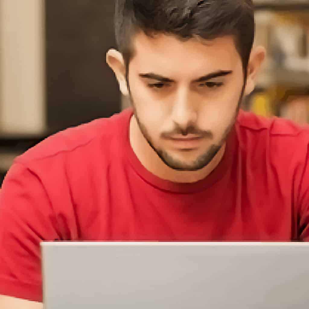 Man works intently on a laptop
