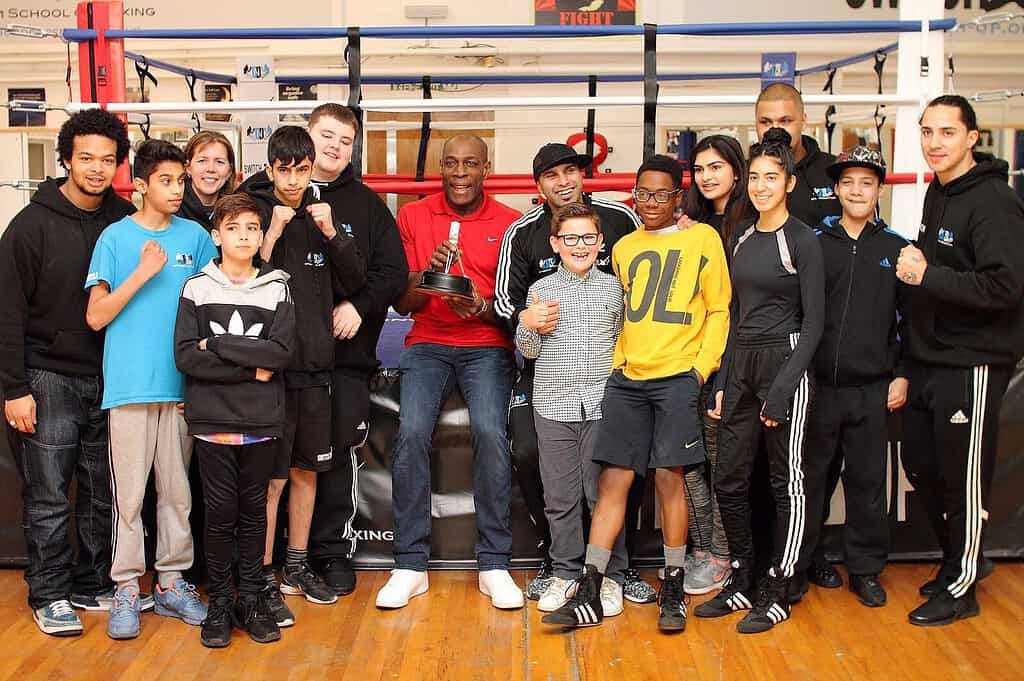 Acumen Fellow Marcells Baz poses with youths at boxing gym in the United Kingdom