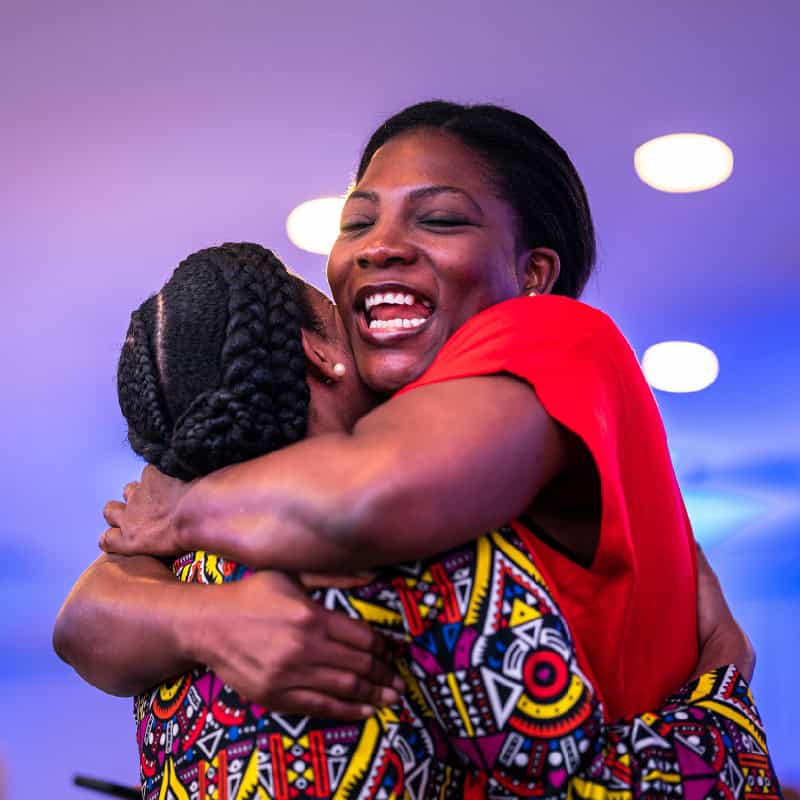 Women excitedly hugs other women in West Africa