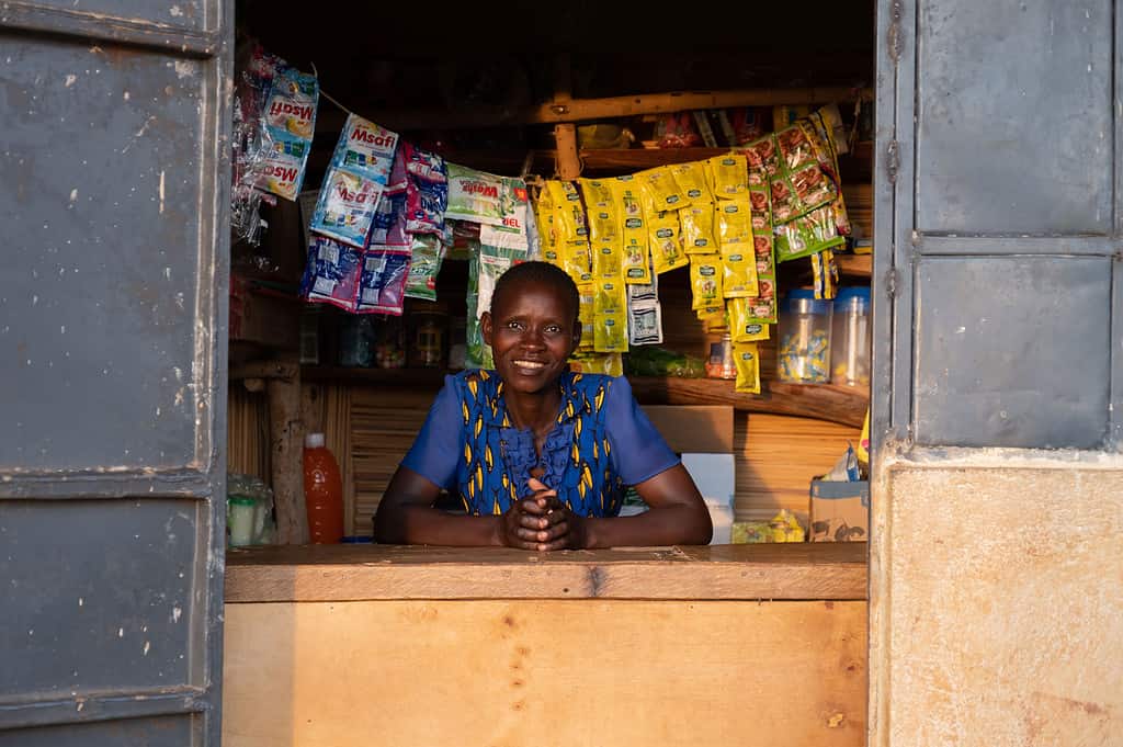 Women cheerful smiles while running her grocery store in East Africa
