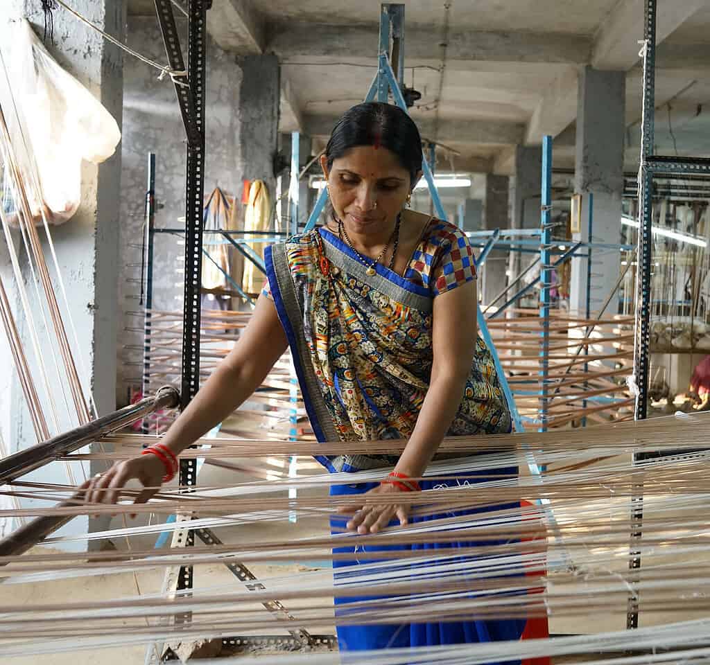 Woman is preparing to weave fabric in a Indian factory