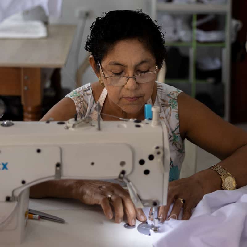 Seamstress carefully sews garment in a factory in Colombia