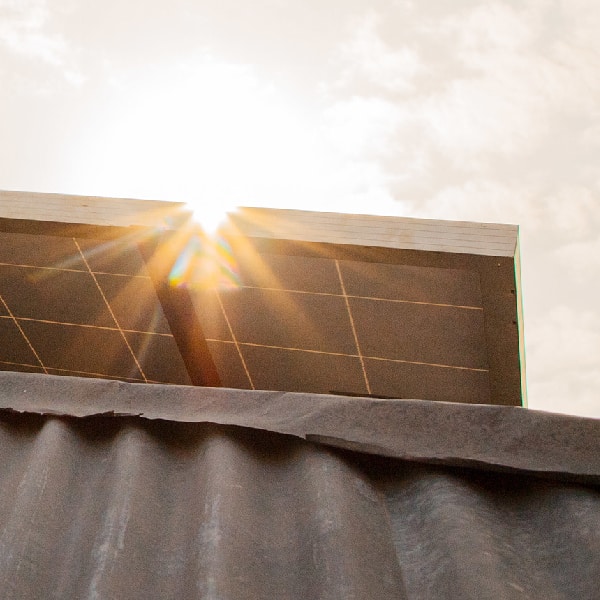 A solar panel on top of a building receiving sun light