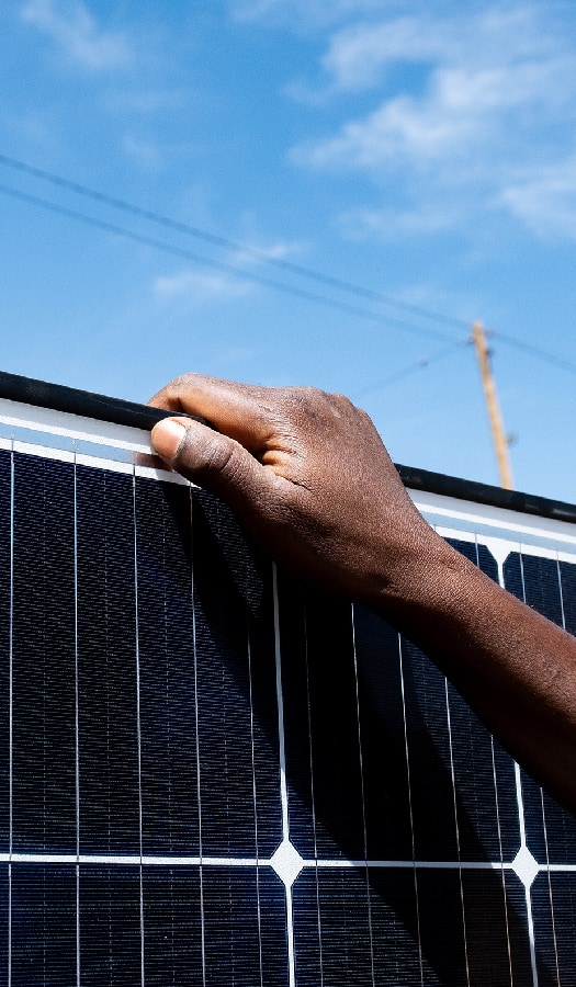 Hand grasps solar panel in East Africa
