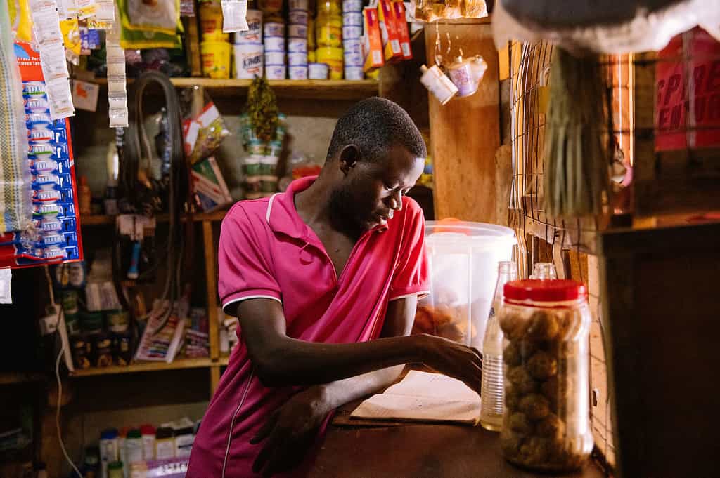 Shopkeeper reviews ledger in East African shop