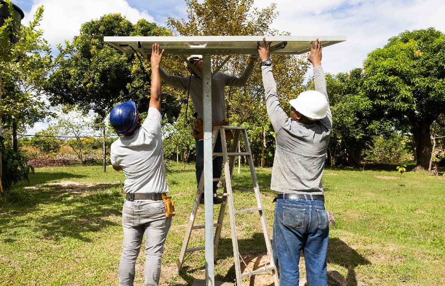 Workers installing solar panel system in home garden in Colombia