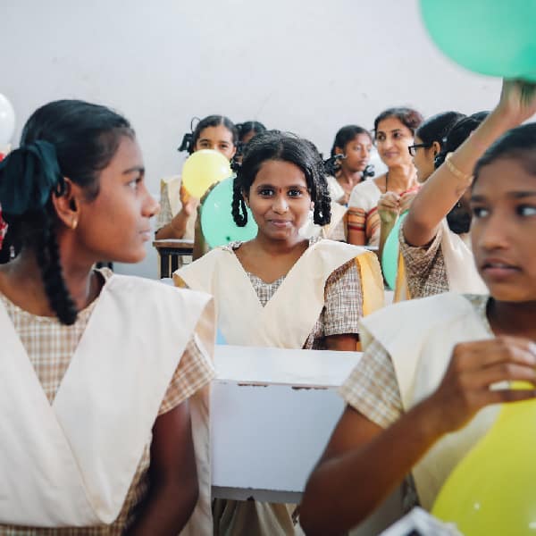 A classroom full of cheerful and energetic girls preparing for class in India