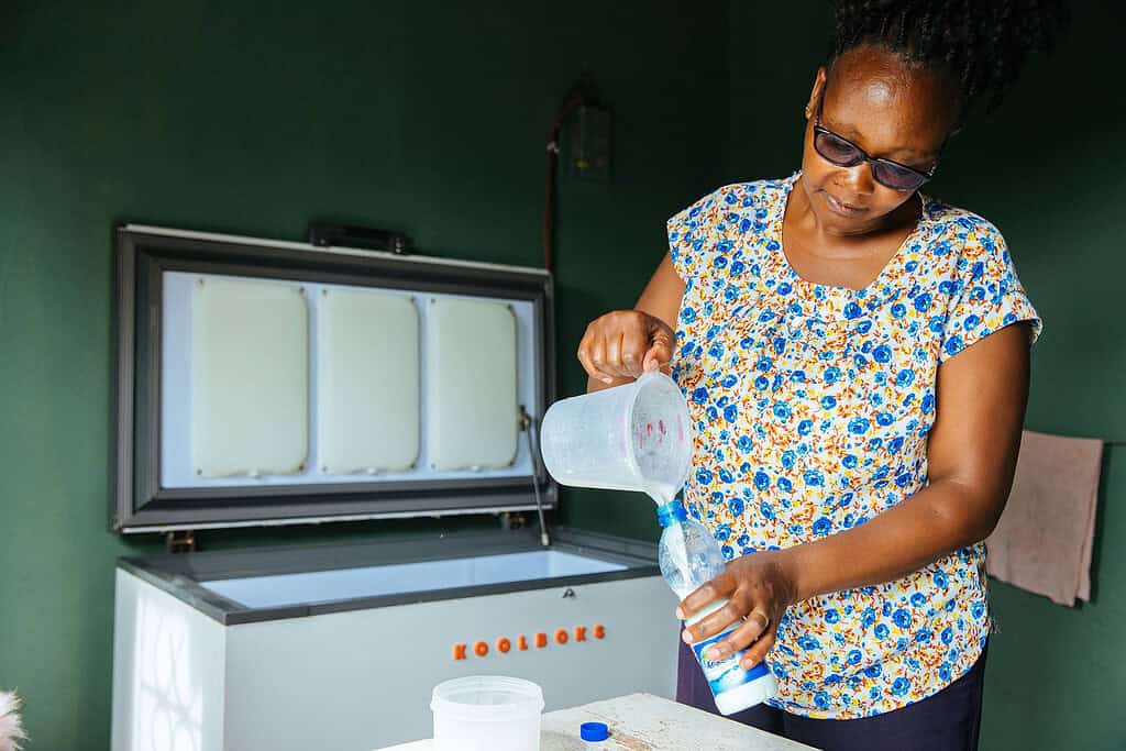 Women pours fresh milk into plastic bottle before storing in Koolboks cooler