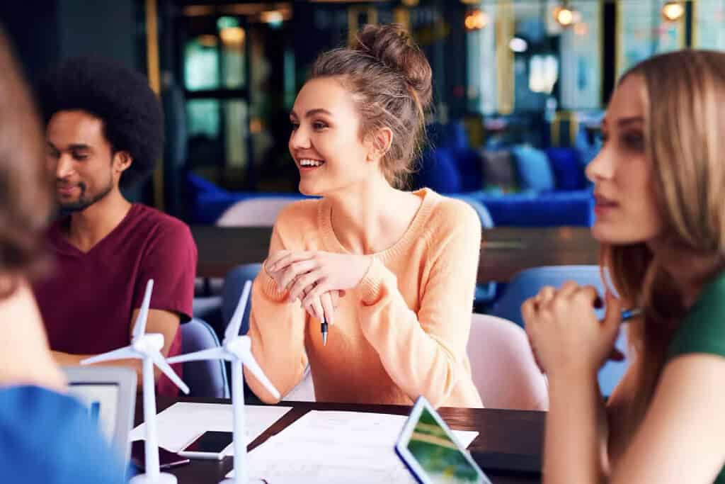 Young woman listens cheerfully at work meeting