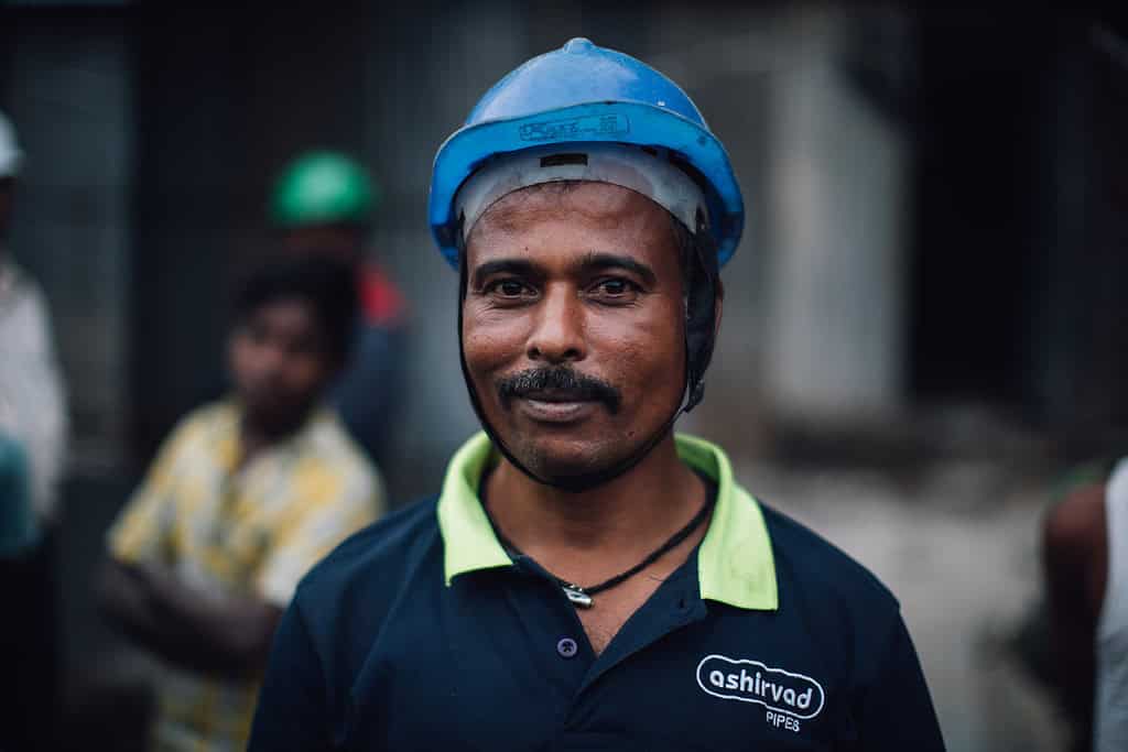 Worker smiles while on a construction worksite in India