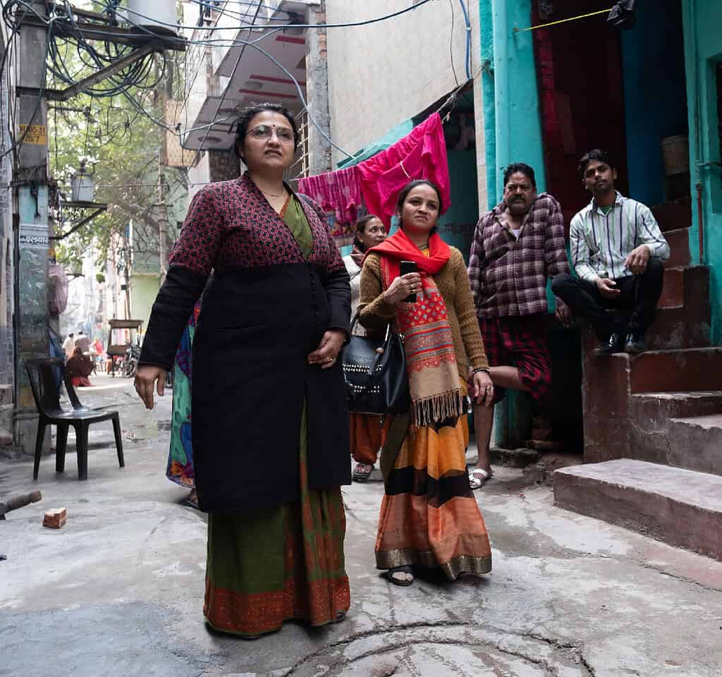 Two women walk through a Indian city neighborhood