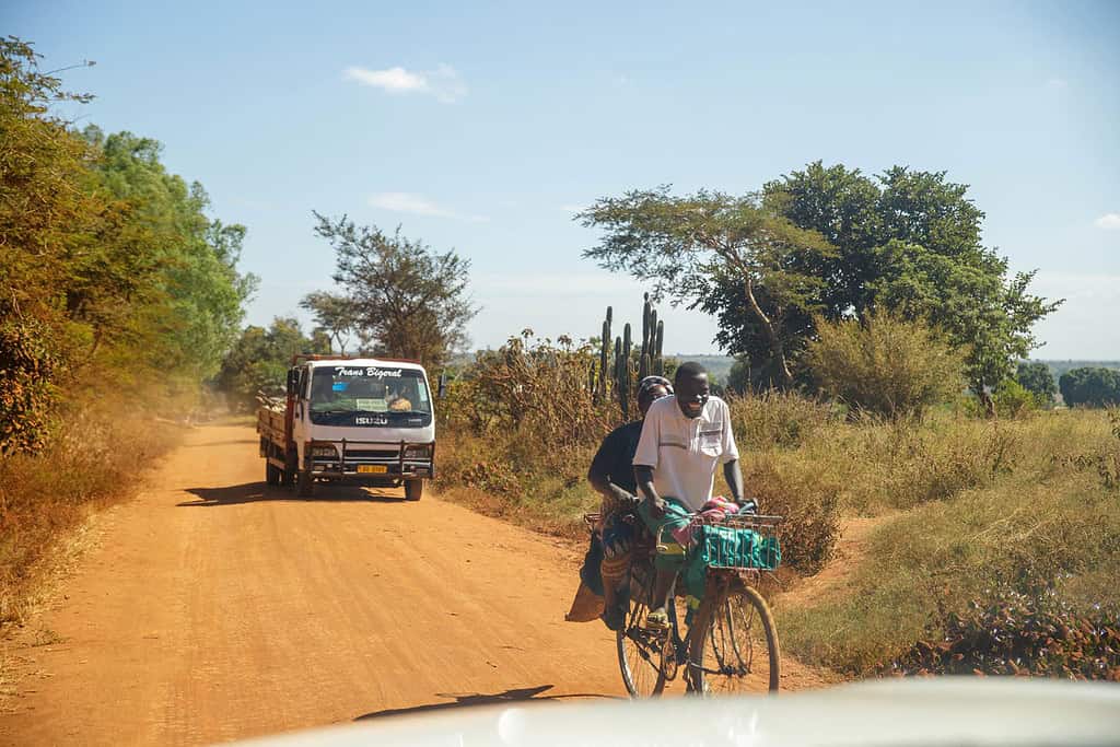 Man and women ride bike on Malawi road with cars