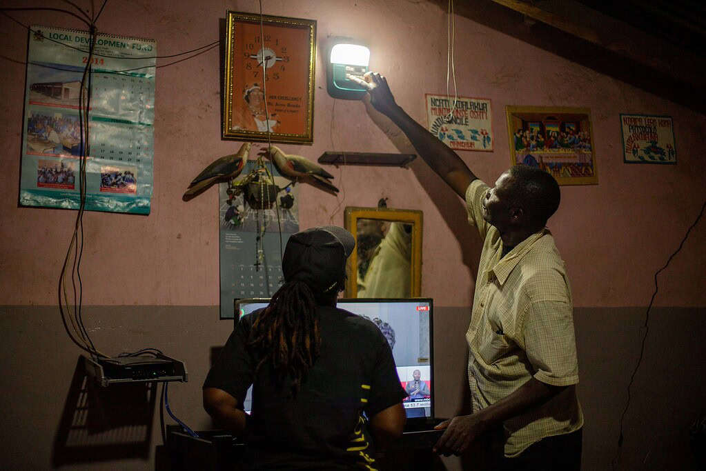 Technician adjusts solar powered light for customer in her home