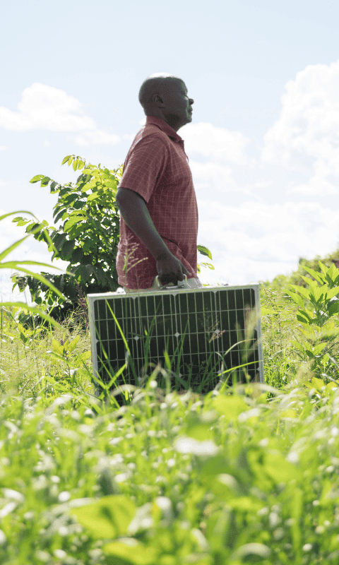 Man with solar panel in field