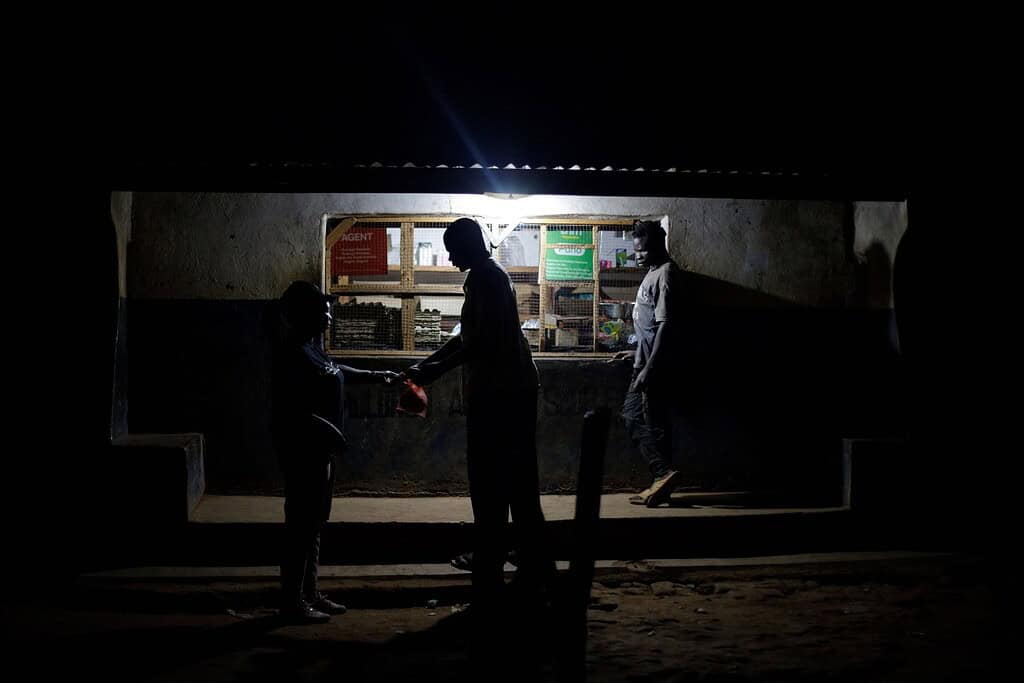 People in front of brightly lit store
