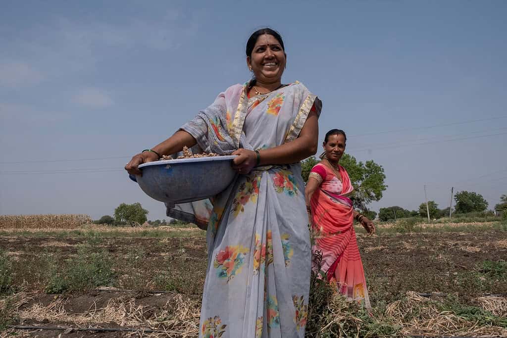 An Indian farmer holiding produce.