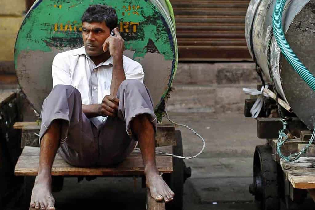 An Indian man seated and on the phone.