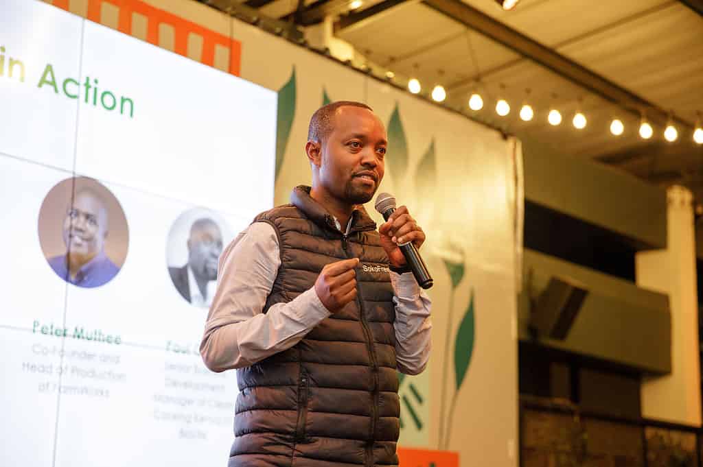 Man delivers speech at the main stage of the 2023 Acumen Climate Summit