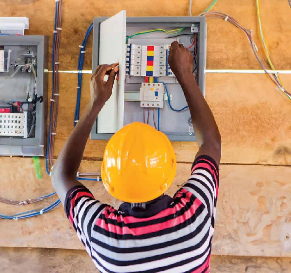 Worker installing wires and connecting electrical conduit box
