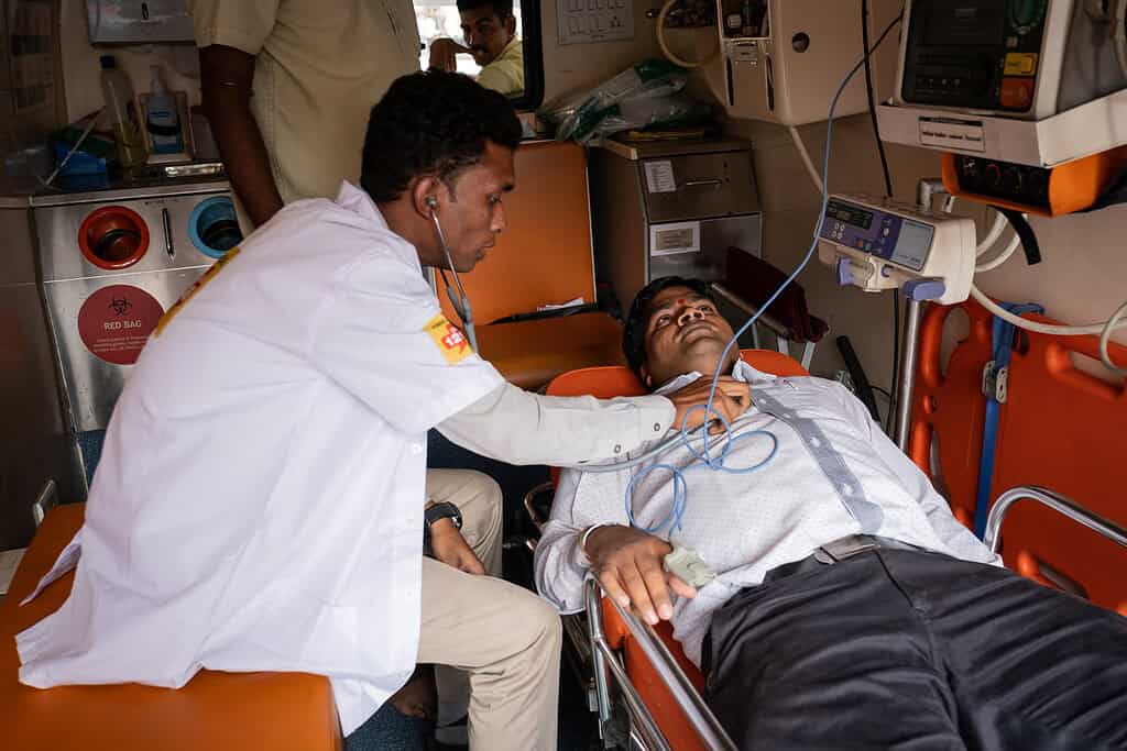 Medical professional conducts examination in the back of a Ziqitza ambulette in India