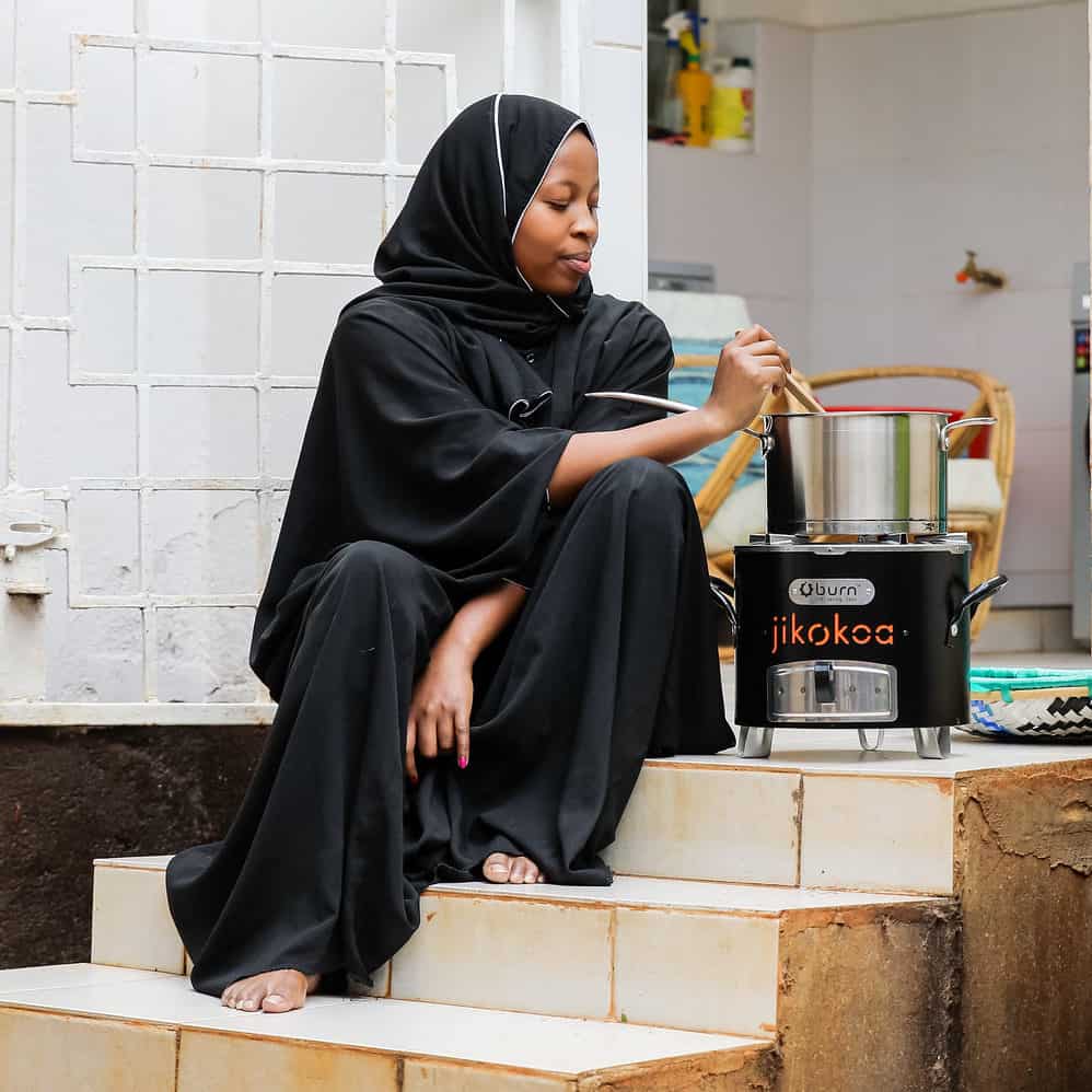 Kenyan woman preparing a meal on a Burn stove