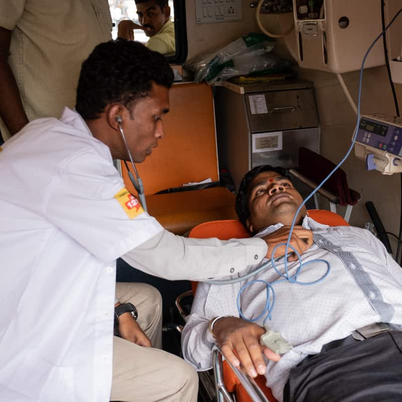 Medical professional conducts examination in the back of a Ziqitza ambulette in India