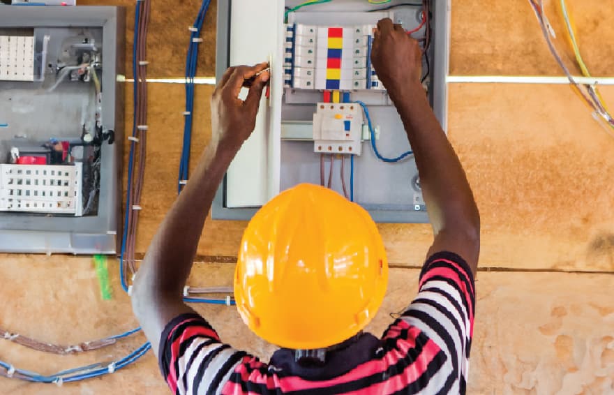 Worker installing wires and connecting electrical conduit box