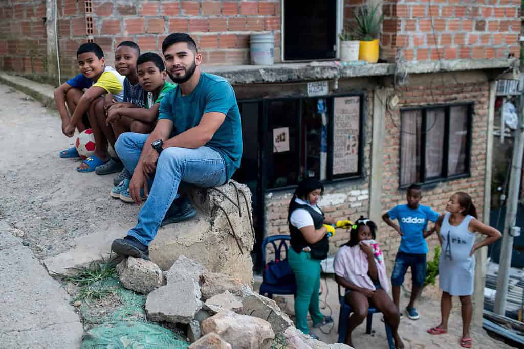 Acumen fellow Andres Felipe Gonzalez Espinosa sits on a sidewalk in a Colombian neighborhood