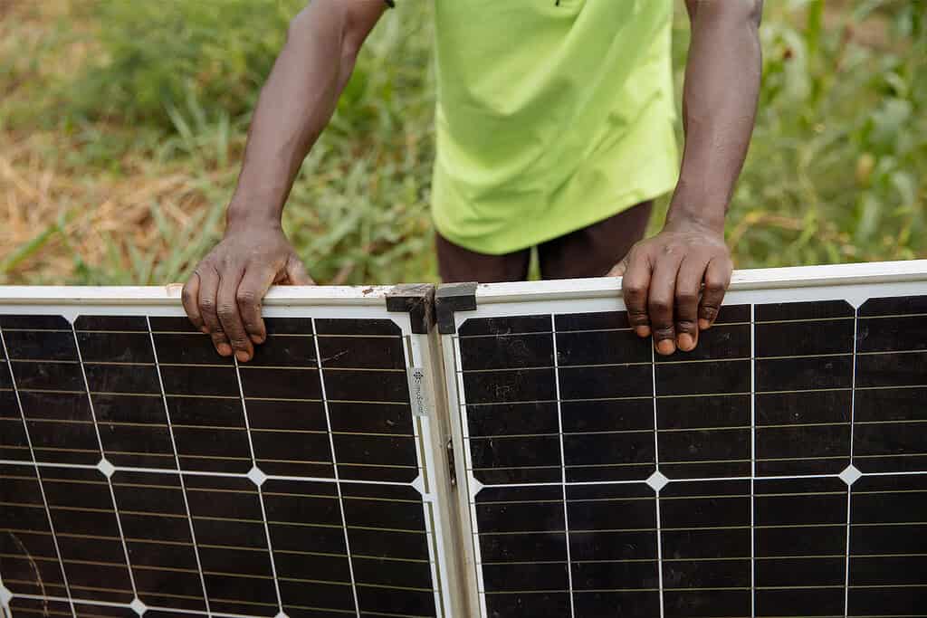 Featured image of man in Africa holding solar panels