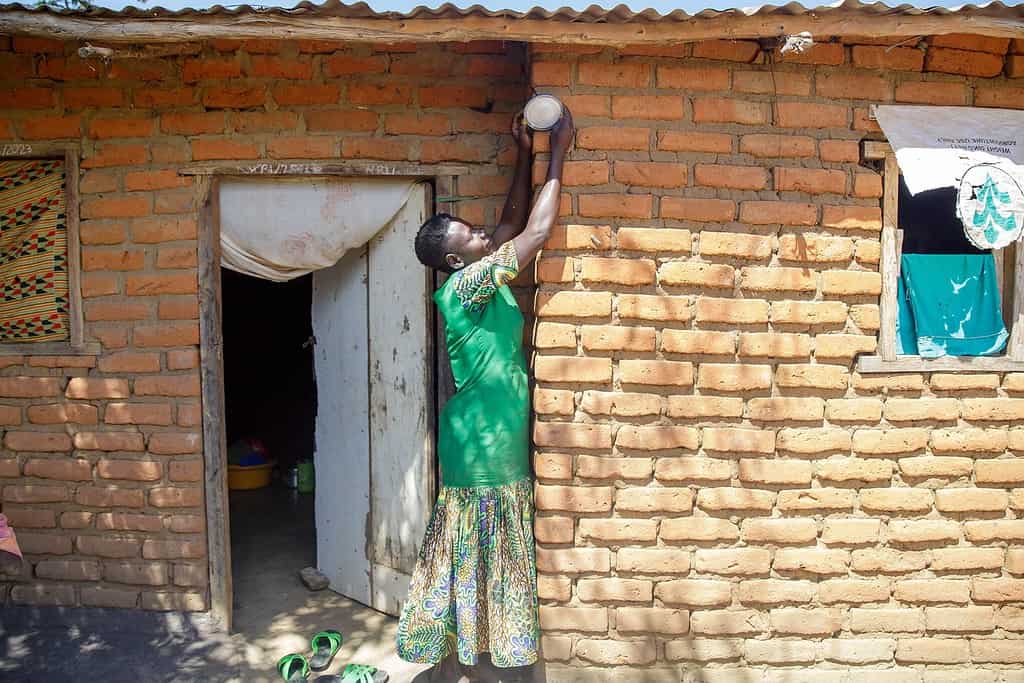 Woman adjusts solar powered light on her home