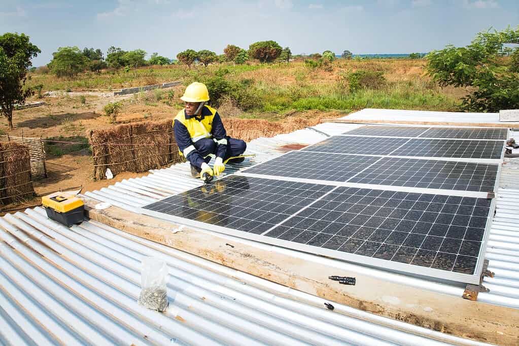Technician installs solar panel on roof